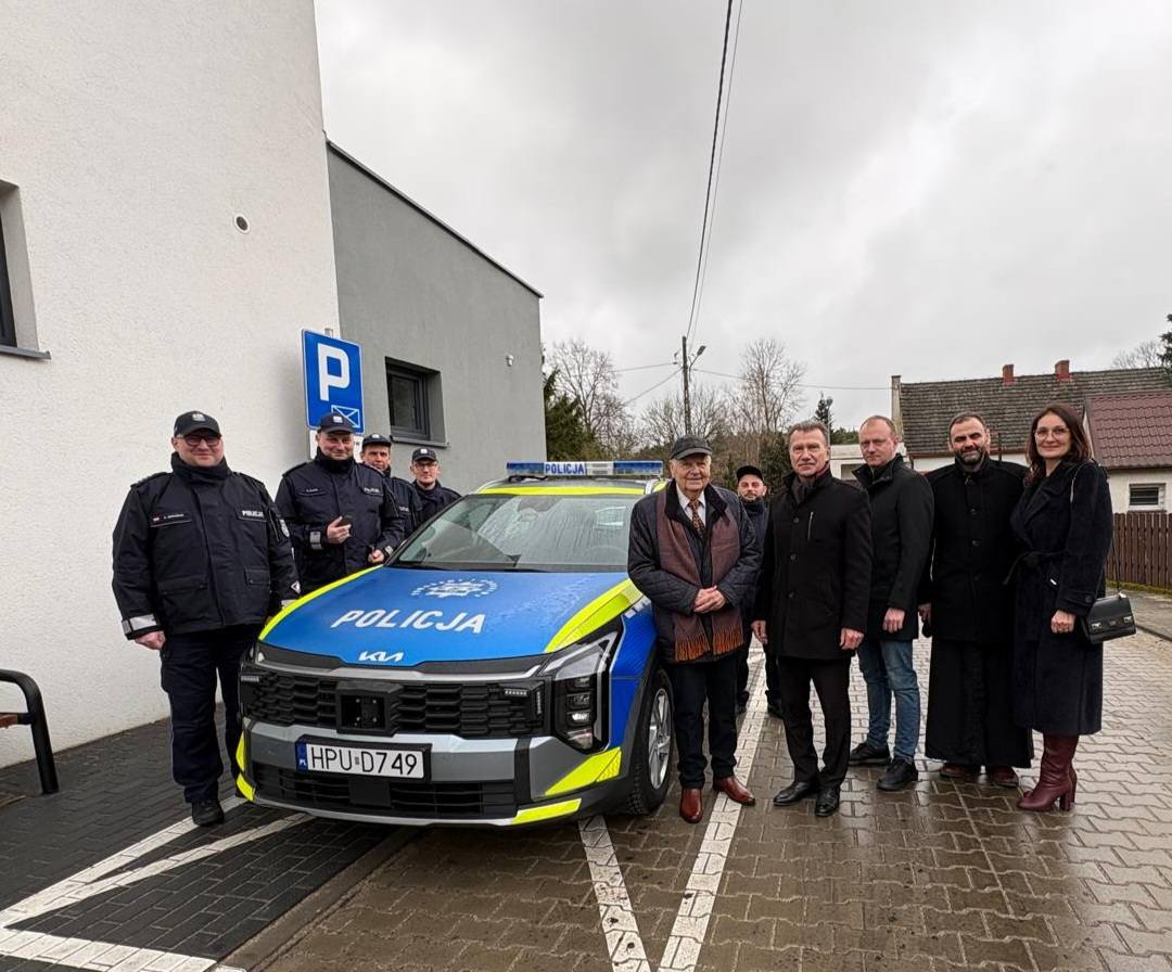 Wspólne zdjęcie przekazania nowego pojazdu. Po prawej stoją pracownicy Policji, a po prawej stronie stoją pracownicy władzy gminy wraz z Przewodniczącym Stowarzyszenia oraz Ks. Proboszcz Parafii w Miedzichowie..